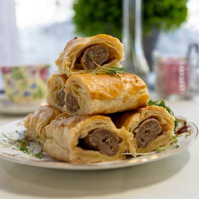 Stacked sausage rolls on a plate.