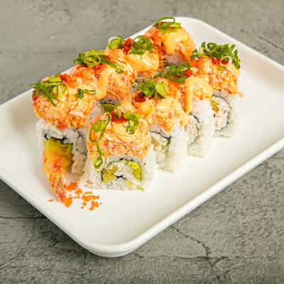 Sushi rolls topped with spicy mayo on a plate.