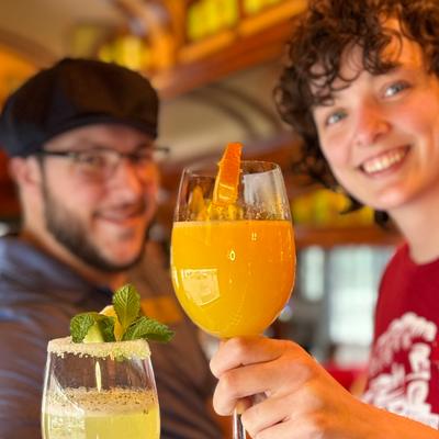 Two people holding cocktails.