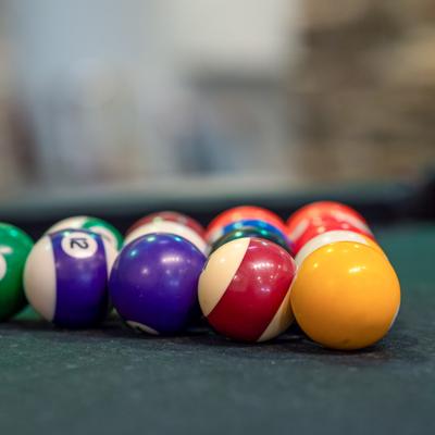 A set of pool balls racked on a green felt billiard table.