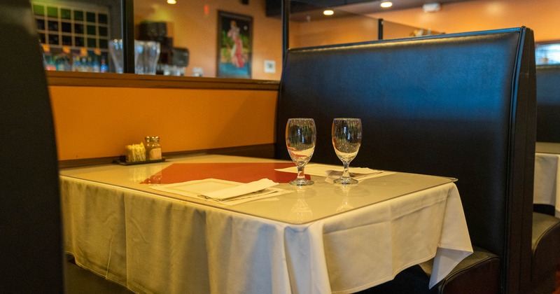 Cozy restaurant interior with wooden floors, elegantly set tables