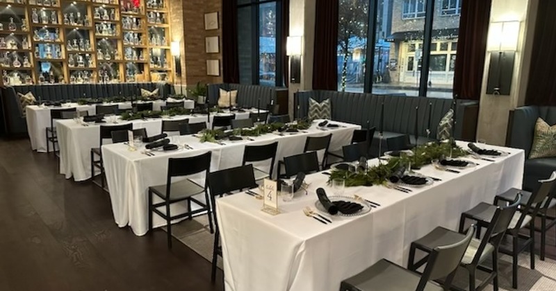 Elegant restaurant setup with tables and chairs, decorated for an event