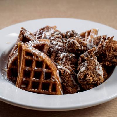 Sweet potato waffles and crispy fried chicken wings, served.