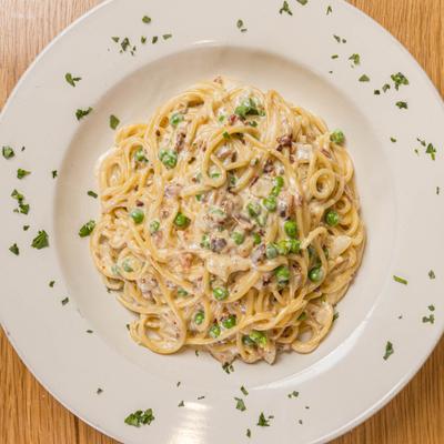 Spaghetti Carbonara with herb garnish, overhead view.