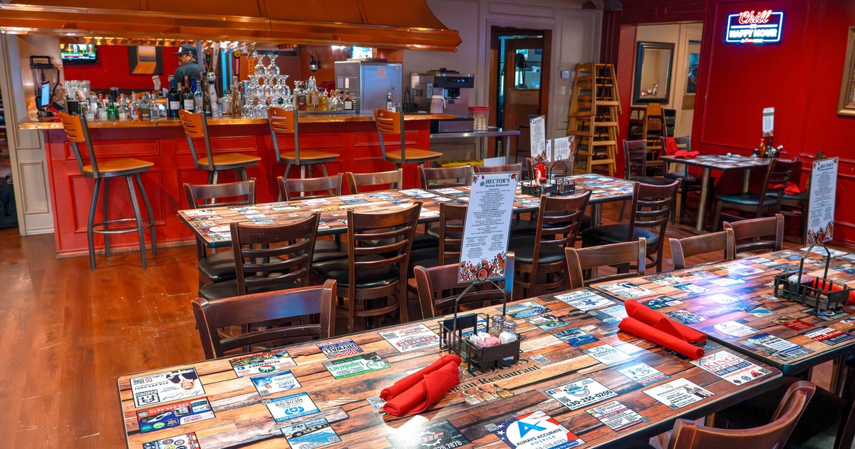 Interior of a lively restaurant with tables and a bright red bar area
