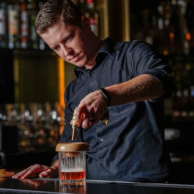 Bartender smoking and Old Fashioned cocktail.