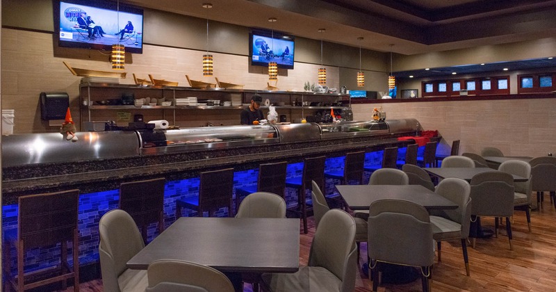 Interior, long marble top bar with stools, tables and chairs, prep station behind the bar