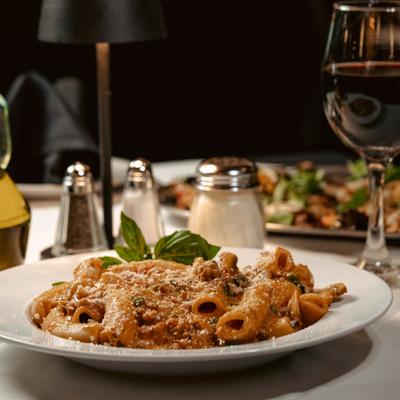Orecchiette pasta with crumbled sausage in a garlic sauce served with red vine.