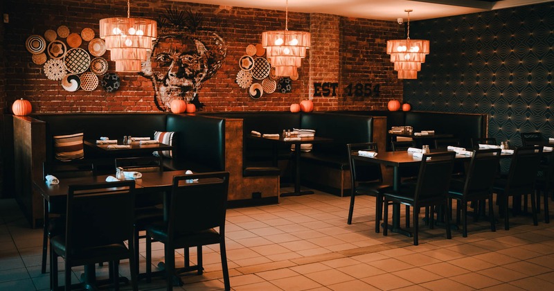 Interior, dining area, tables for four and eight, seating booths, red brick wall