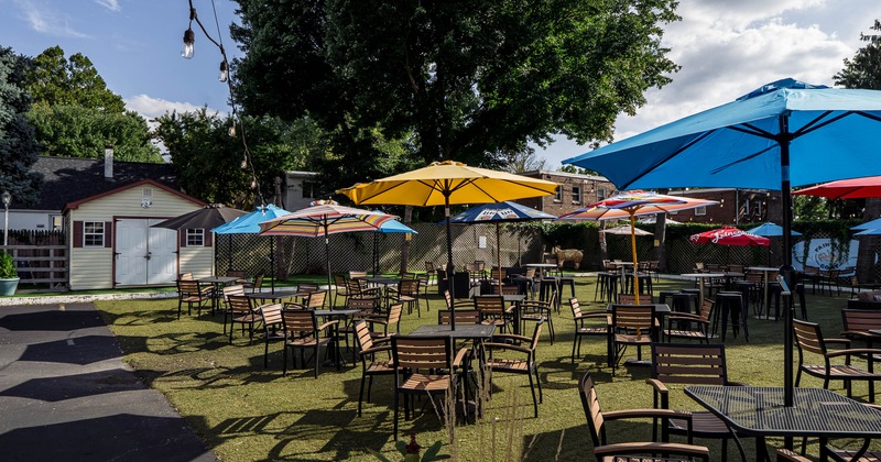 Outdoor patio with tables, chairs, and colorful umbrellas