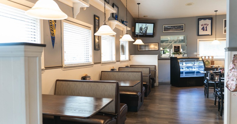 Interior of a diner with booths, pendant lights and a display case