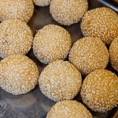 Sesame balls arranged on a metal tray.