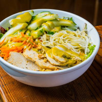 Grilled chicken salad with avocado and shredded vegetables.