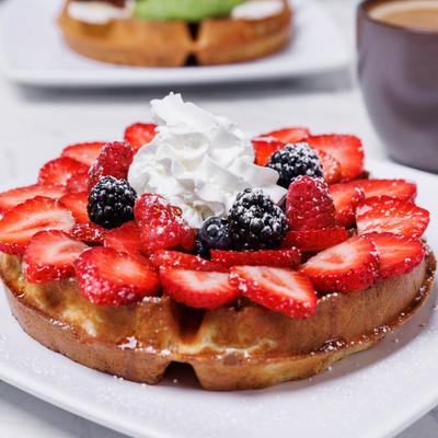 Waffles topped with fresh berries and whipped cream.