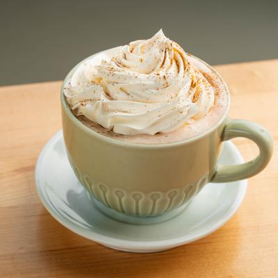 Cup of hot drink topped with whipped cream.