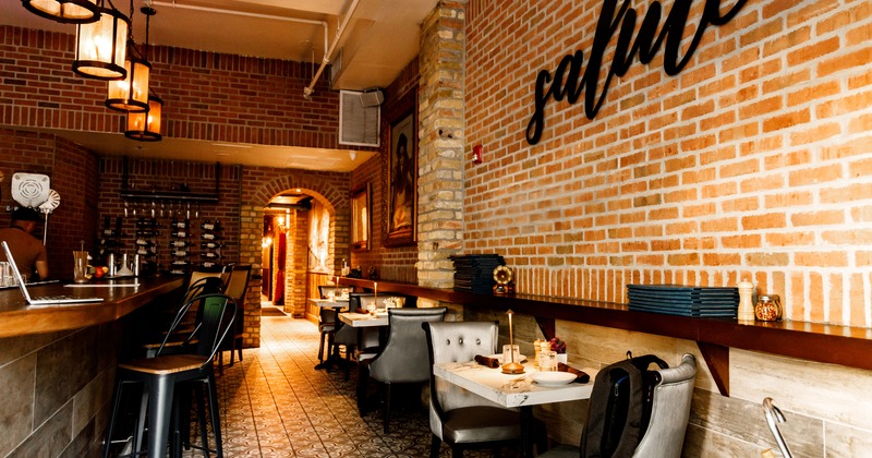 Modern style of interior design with a bar and set dining tables along the brick wall