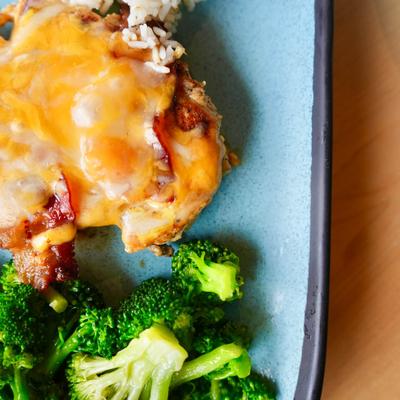 Grilled chicken, with melted cheese, bacon, rice, and broccoli.