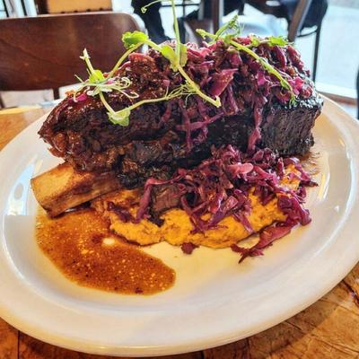 Pork shank on a bed of mashed potatoes.