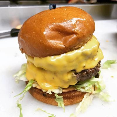 Double cheeseburger with melted cheese on a toasted bun.