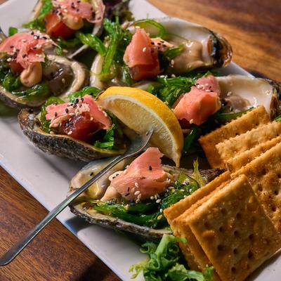 Oysters with seaweed, tuna, and crackers.