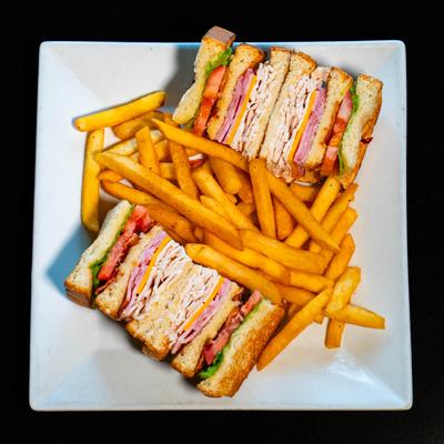 Deluxe Club sandwich with fries, top view.