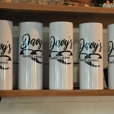 Interior, White tumblers with the company's logo on a shelf.