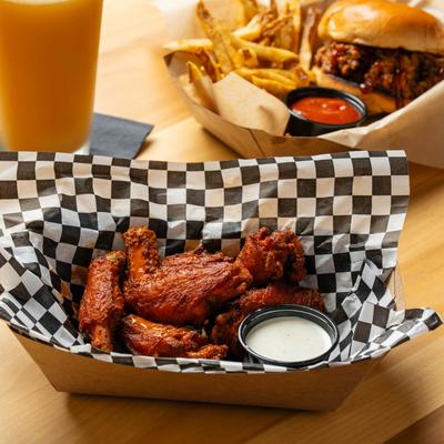 Pub wings, sloppy joe sandwich with fries and orange and amber beers.