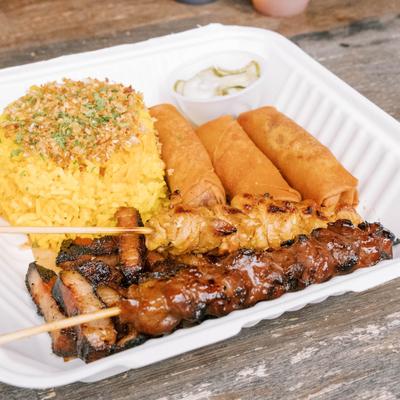 Grilled skewers served with rice and spring rolls.