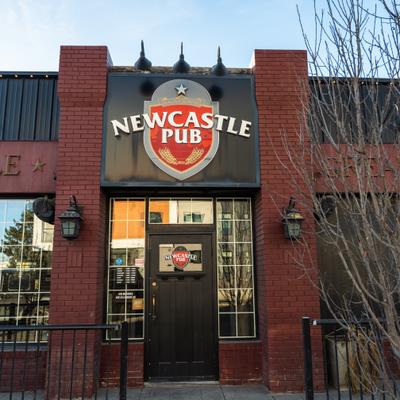 Storefront with brick facade, entrance and a sign.