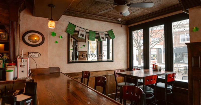 A cozy pub interior with a wooden bar, seating area and Guinness-themed decor.