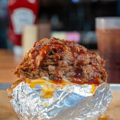 Baked potato loaded with pulled pork, grilled onions and cheese.