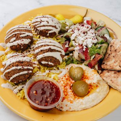 Falafel drizzled with tahini, served with hummus, pita and a salad.
