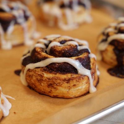 Cinnamon roll drizzled with white sauce.