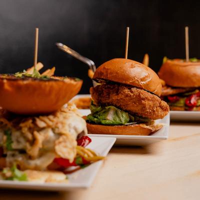 Chicken Caesar Sandwich displayed with assorted burger sandwich plates.