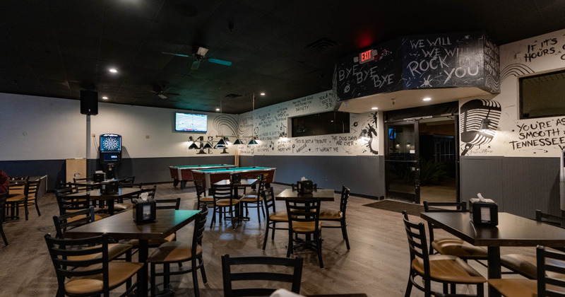 Interior, guest tables and chairs with a gaming area in the back