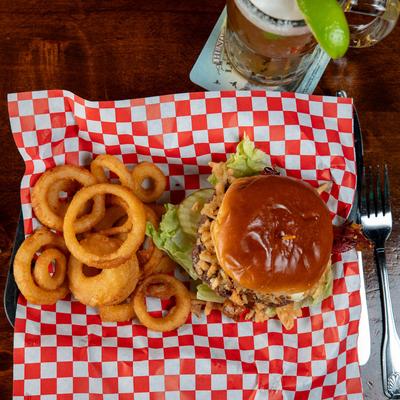 Burger with onion rings and beer, top view.