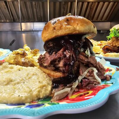 Smoked Brisket Sandwich, served with cheese grits and hash browns.