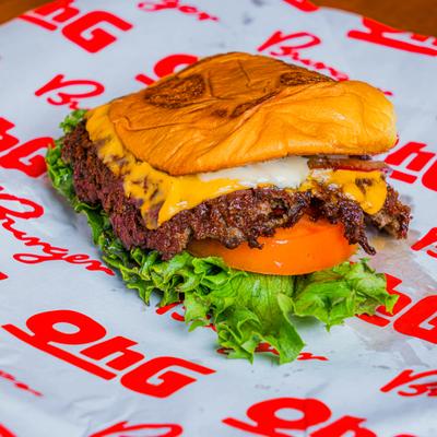 Cheeseburger topped with lettuce and tomato.