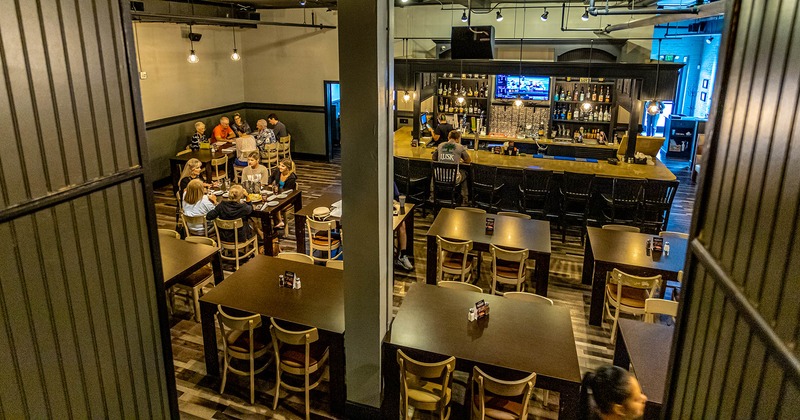 Interior, seating space around a bar, guests dining