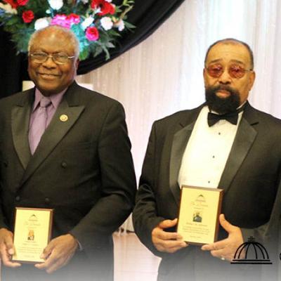 Two award recipients holding plaques.