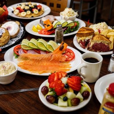 Table spread featuring various breakfast dishes served alongside a cup of coffee.