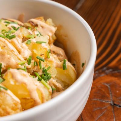 Roasted Potatoes topped with chipotle crema, close-up.