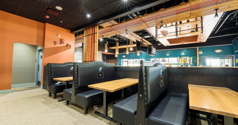 Interior of a restaurant featuring booths and tables.
