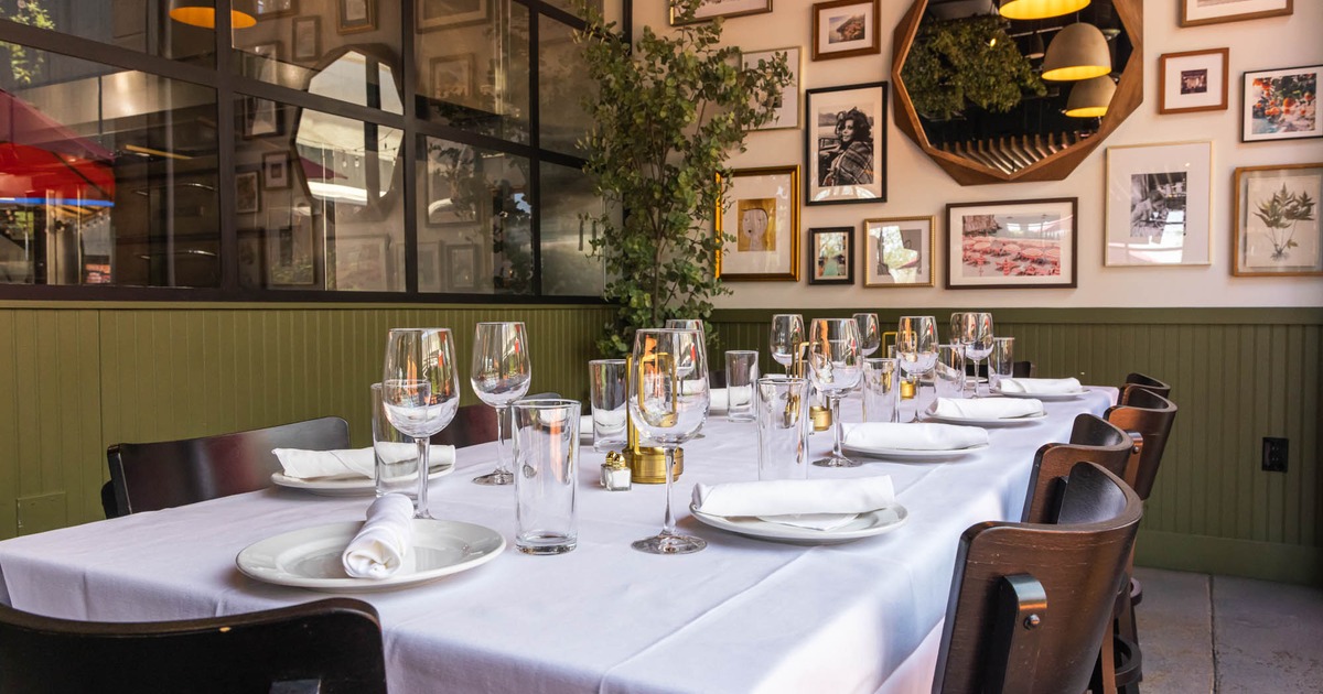 Elegant dining setup with a white tablecloth, neatly arranged glassware, and napkins