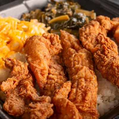 Fried chicken served with mac and cheese and collard greens.