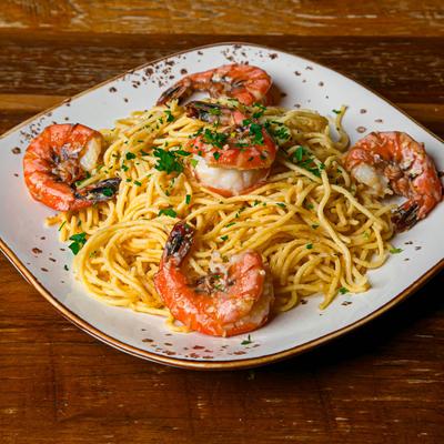 Garlic noodles with shrimp on a wooden table.