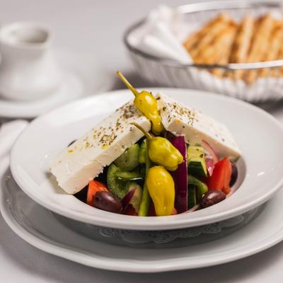 Greek salad with pita bread in the background.