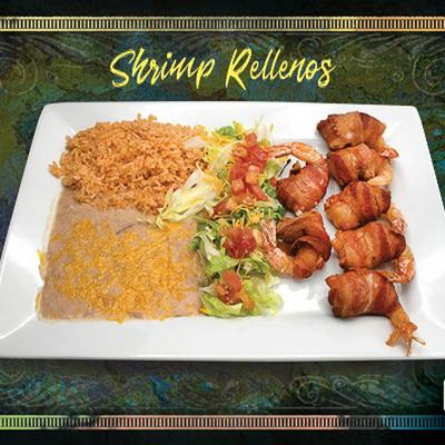 Bacon wraped shrimp served with rice, beans and salad.
