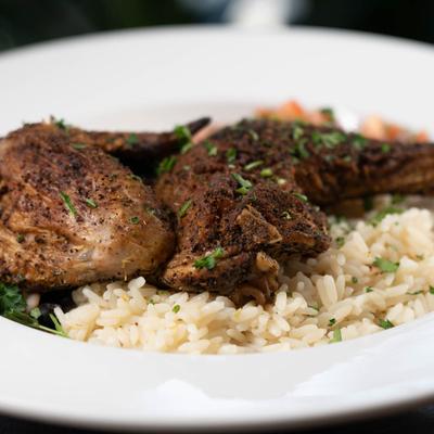 Half Chicken Lanzaga Coffee Rub Marinated in Oregano served on a bed of rice.
