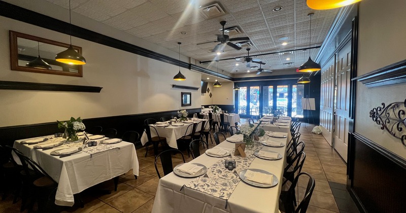 Tables set with white linens for an event in the large dining space at 310 Park South.